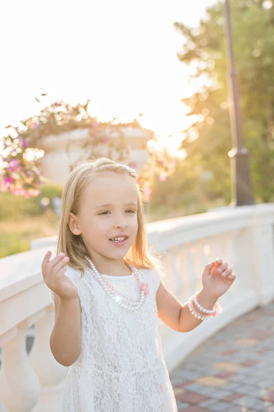 Vacker Och Glad Liten Blond Flicka Vit Klänning Pärlor Tittar — Stockfoto