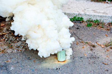 Kaldırımda sis bombası yakmak için kalın sarı bir duman çıkıyor. Sis perdesi. Yumuşak oyun. Sinema, video ve fotoğraflarda özel efektler. havai fişekler ve selamlar Ultra