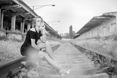 Uzun saçlı, uzun siyah kısa elbiseli, uzun bacaklı üzgün ve yalnız bir kız demiryolu raylarında oturur. Kaybetmenin acısı, kayıp, kırık kalp, sevdiğinden ayrıldıktan sonra hayal kırıklığı.