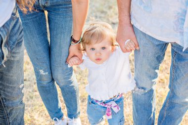 Geniş bir portre, üst manzara, güzel bir çocuk kafasını kaldırıyor, büyük mutlu bir aile ellerini tutuyor: anne, baba, büyükanne, büyükbaba. Birbirine bağlı aile kavramı, çocuklarla ilgilenmek, aileler her zaman oradadır..