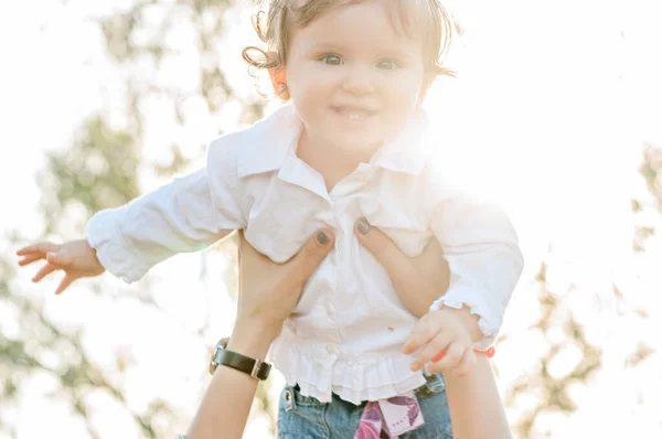 Beautiful Young Brunette Mother Long Curly Hair Throws Little Daughter — Stock Photo, Image