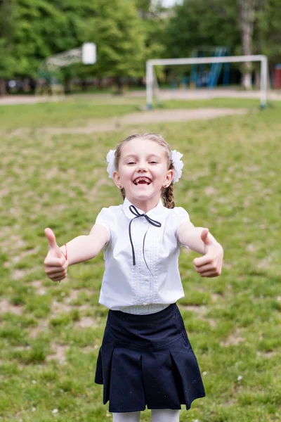 Liten Blond Skolflicka Skoluniform Med Vita Rosetter Flätor Visar Cool — Stockfoto