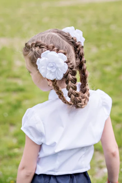 Mała Blondynka Szkolnym Mundurku Stoi Plecami Kamery Demonstruje Szkolną Fryzurę — Zdjęcie stockowe