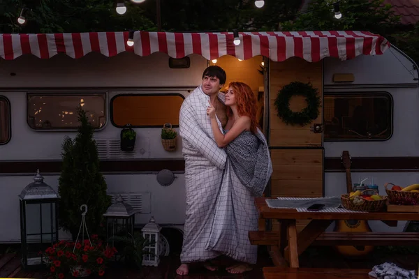 幸せな愛好家の若いカップルが夜にトレーラートラックで白い毛布に包まれ ライトが家の中にあり ライトが掛けられています 2つのための新婚旅行 屈託のない自由な生活 冒険のスリル — ストック写真
