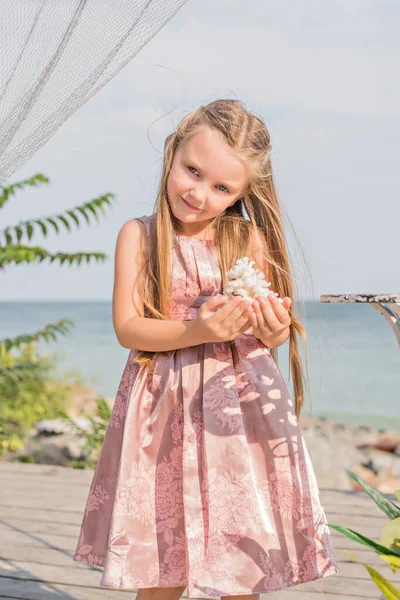 Uma Menina Loira Fofa Vestido Rosa Suave Segura Coral Suas — Fotografia de Stock