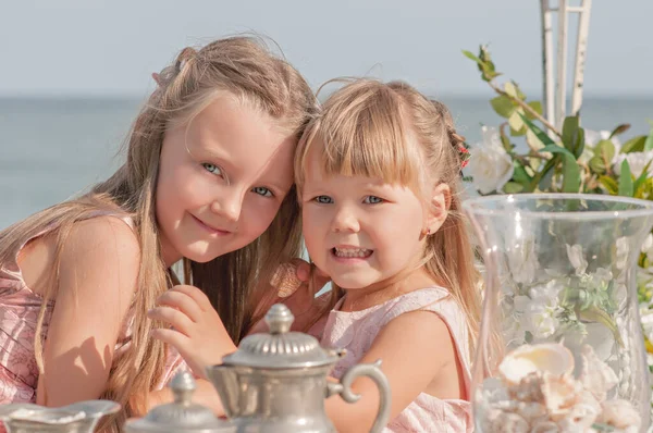 Mooie Blonde Zusters Meisjes Roze Jurken Spelen Aan Tafel Zee — Stockfoto