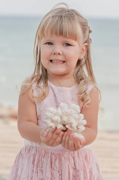 Little Cute Blonde Girl Gentle Pink Dress Holds Coral Her — Stock Photo, Image