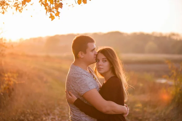 一个年轻的男人亲吻 拥抱一个美丽的金发女孩 一对情侣在秋天森林的背景下拥抱的特写 恋爱中的快乐情人一起旅行 — 图库照片