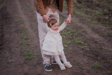 Baba ve küçük kız gün batımında çiçek açan bahçelerde el ele yürüyorlar. Genç bir adam kızın kollarının etrafında dönüyor, kız gülüyor. Ebeveynler ve çocuklar arasındaki ilişki, ebeveynlik. Mutlu aile