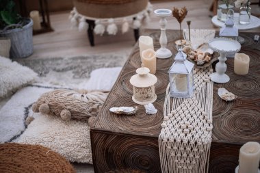 Şehre bakan açık bir terasta dekore edilmiş. Marakanlarda, Hindistanda, kum renklerinde eko-stil: hasır mobilya, makrome, mumlu fenerler, cam lambalar, pampalar, puflar, alçak masa.