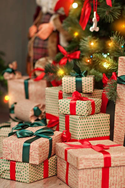 圣诞树下的一座座高高的礼物山 装饰着红绿工艺包装的彩带蝴蝶结彩灯 新年贺卡 度假时美丽迷人的风景 圣诞老人 — 图库照片