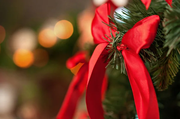 新年贺卡 圣诞树上装饰着红色的大蝴蝶结 白色的姜饼挂在绳子上 背景上闪烁着亮晶晶的奶茶 圣诞老人的雕像 复制空间 — 图库照片