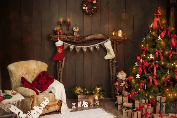 Eski odunlardan yapılmış ahşap bir şöminenin üzerinde sihirli yazılar ve Noel Baba 'nın hediyeleri için beyaz-kırmızı çoraplar asılı bayraklar var. Yılbaşı kartı ve yılbaşı ağacı. Boşluğu kopyala