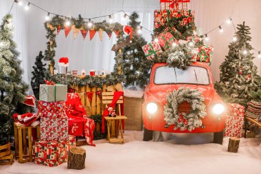 Kırmızı renkli sihirli kart. Yılbaşı ışıkları, çelenkler, Noel ağaçlarının dalları, beyaz-yeşil ambalaj kağıdına sarılı hediye kutuları, çam iğnelerinden bir çelenk. Boşluk dokusunu kopyala