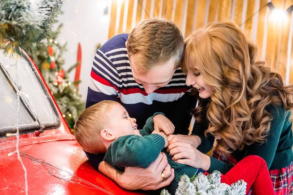 가족은 선물과 크리스마스 화환으로 근처에서 아들과 즐겁게 어머니와 아버지가 아이를 — 스톡 사진