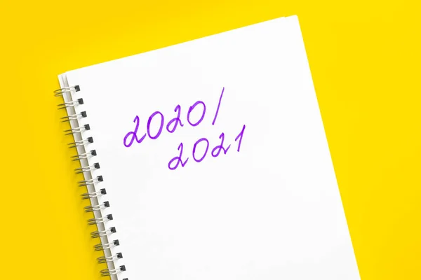 Zurück zur Schule. Konzept für das neue Schuljahr und Rückkehr zur Schule. Die Inschrift 2020 - 2021 in einem weißen Notizbuch mit Spirale, auf gelbem Hintergrund. — Stockfoto