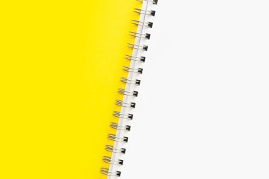 Yerleşim ya da modelleme. Sarı zemin üzerinde spiral olan açık bir defterin beyaz sayfası. Metin için boşluk ya da boşluk kopyala