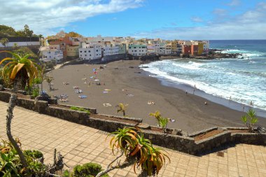 Nisan 2019, Puerto de la Cruz, Kanarya Adaları, İspanya. Sahilde büyük dalgalı siyah volkanik kum. 