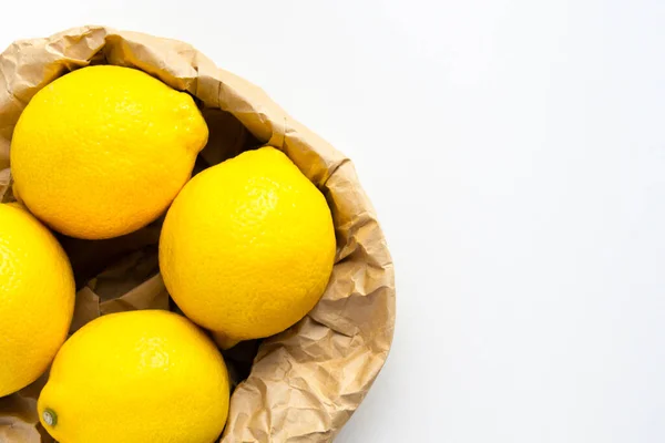 Beyaz arka planda dört olgun limon. Geri dönüşüm poşetinde bir grup taze limon. — Stok fotoğraf