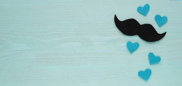 Banner with felt fabric mustache and blue hearts, creative Happy fathers day background with space for text.