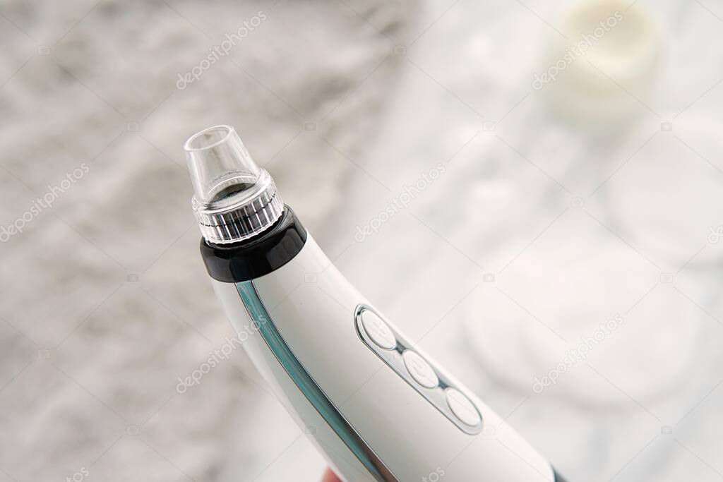 Vacuum blackhead remover close up, home cosmetic procedure.
