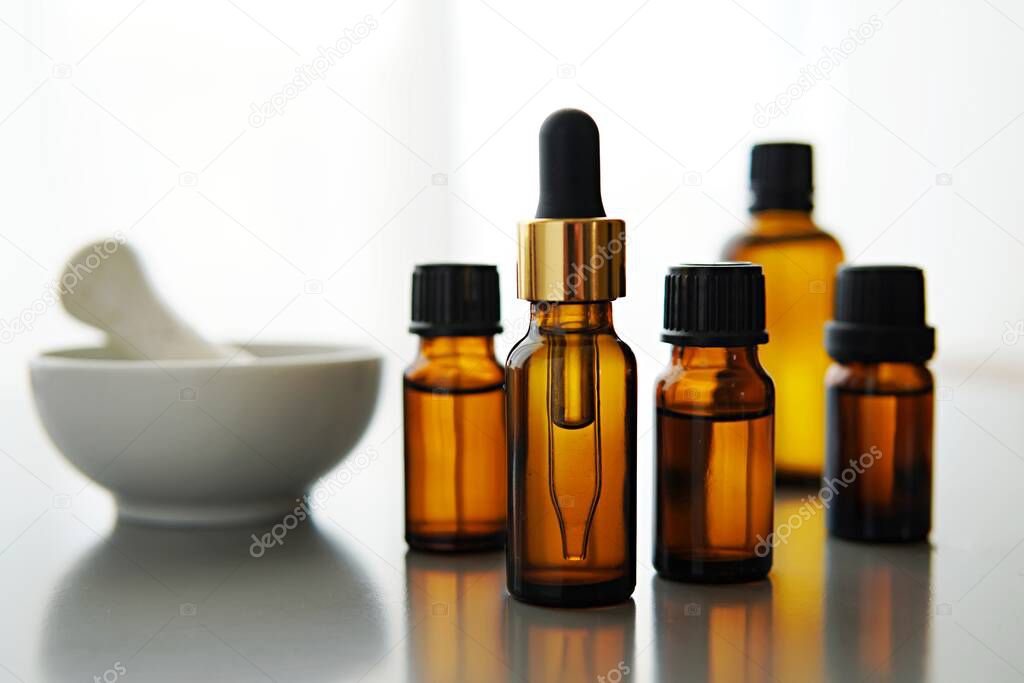 Brown amber bottles with essential oil, cosmetic oils, mortar and pestle, aromatherapy, phytotherapy, alternative medicine, natural skin care.