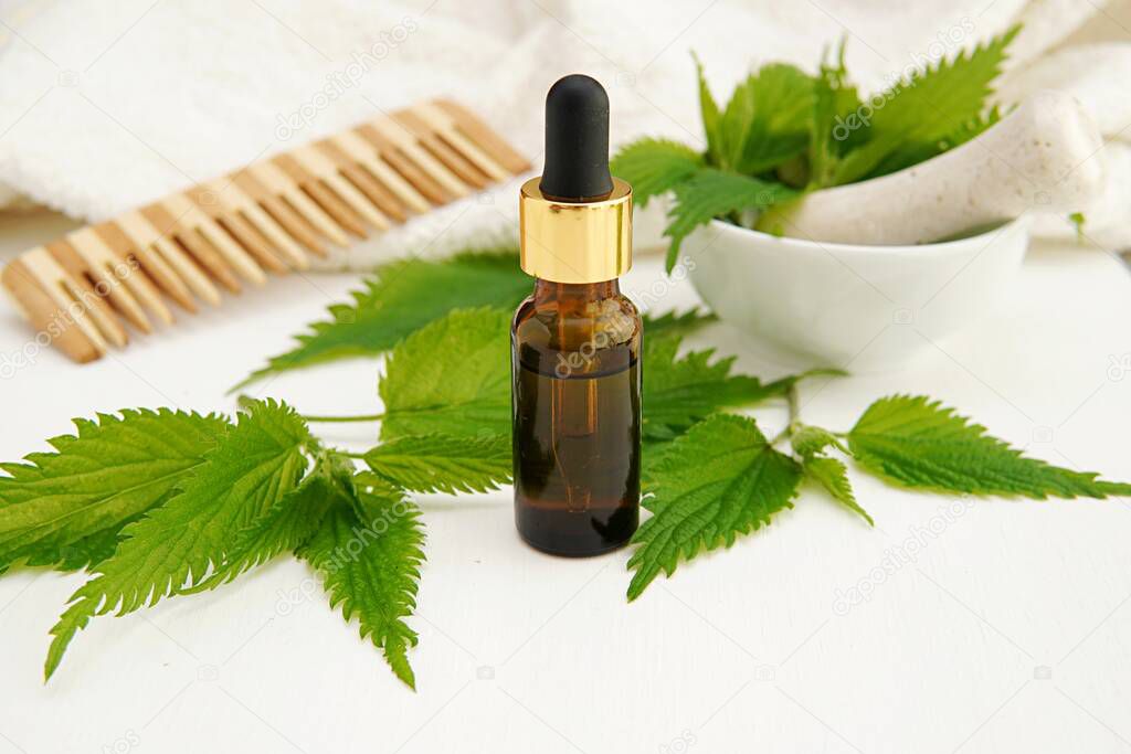 Stinging nettle extract in amber glass bottle, natural hair care product.