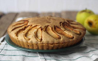 Doğal ahşap bir masada peçeteye çikolata parçalı elmalı kek eklendi. Sağlıklı ev yapımı kekler..