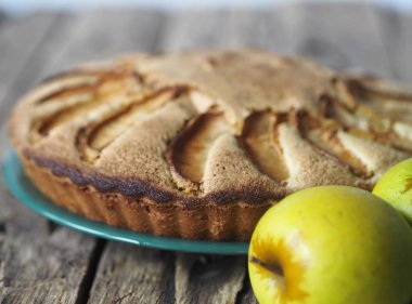 Doğal ahşap bir masada peçeteye çikolata parçalı elmalı kek eklendi. Sağlıklı ev yapımı kekler..