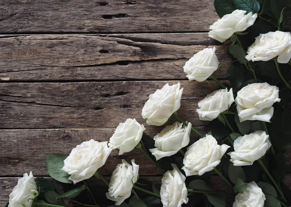 白色的玫瑰在自然的木制背景上呈角度排列 节日问候或明信片 — 图库照片