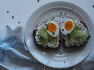 Yukarıdan bak. Organik sandviçler, yumurta ve sebzelerle donatılmış hafif bir arka plan. Sağlıklı doğal yaz yemekleri..