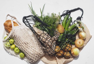 Place for text. Bread and agricultural products, vegetables in knitted bags on a white background. No plastic. clipart