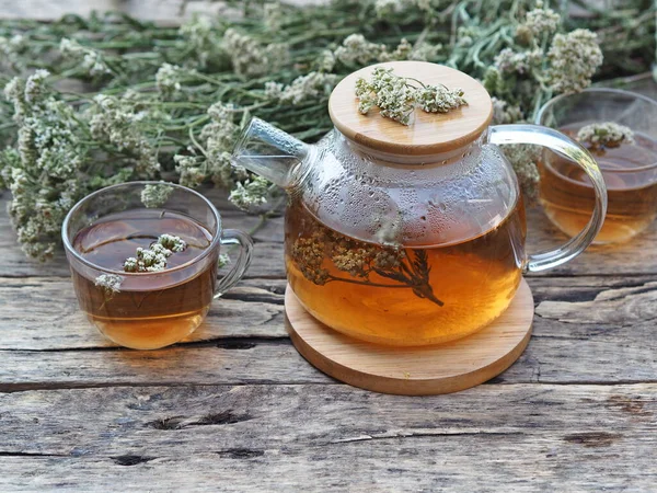 Herbal medicinal background.Healthy tea with yarrow flowers on a wooden rustic table. Place for text.