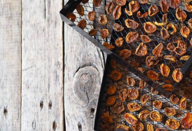 İleride kullanmak üzere kurutulmuş kayısıların tedarik edilmesi. Kurutucudaki kurutucuda kurutulmuş kayısılar, ahşap bir masa üzerinde..