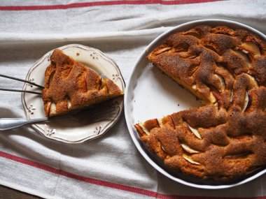 Mutfak geçmişi. Yuvarlak ev yapımı elma turtası, tahta masada kesilmiş..