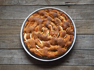 Yuvarlak elmalı turta ya da ahşap kırsal bir masanın ortasında sünger kek. Ev yemeği..