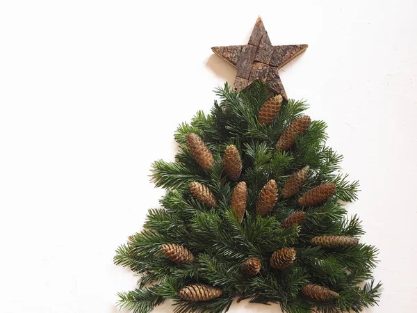 Weihnachtsbaum Aus Tannenzweigen Mit Einem Hölzernen Stern Und Tannenzapfen Auf — Stockfoto