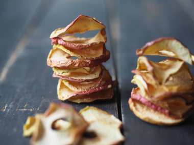 Ev yapımı, kurutulmuş elma cipsleri. Köy ahşap masa üzerinde taze elmalar. Kurutulmuş meyvenin faydaları. Doğal sağlıklı yiyecekler.