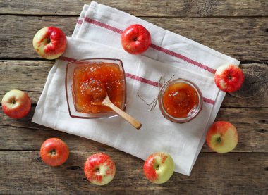 Elmalarla dolu bir sonbahar, ahşap bir arka planda elmalarla çevrili.