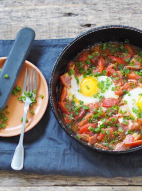 Doğal besleyici yaz yemekleri. Tavada domatesli yumurta ve otlar. Sağlıklı kahvaltı ya da akşam yemeği..