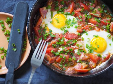Doğal besleyici yaz yemekleri. Tavada domatesli yumurta ve otlar. Sağlıklı kahvaltı ya da akşam yemeği..