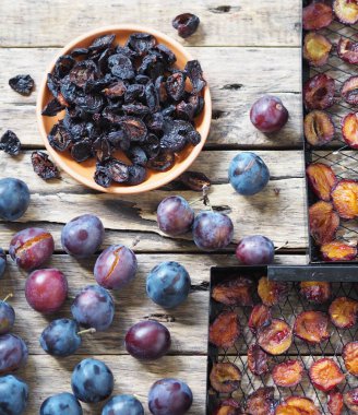 Kurutulmuş meyvelerin ev yapımı. Meyve cipsi. Kurutulmuş erikli ve taze erikli ev meyvesi ve sebze kurutma makinesinin siyah ızgaraları..