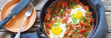 Doğal besleyici yaz yemekleri. Tavada domatesli kızarmış yumurta ve otlar. Sağlıklı kahvaltı ya da akşam yemeği..