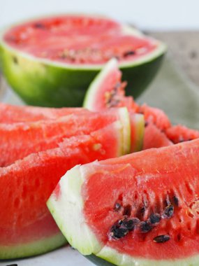 Tahta bir masada olgun kırmızı karpuz dilimleri.