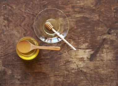 Doğal ahşap bir arka planda tatlım ve ballı bir kaşıkta. Doğal ürünler konsepti.