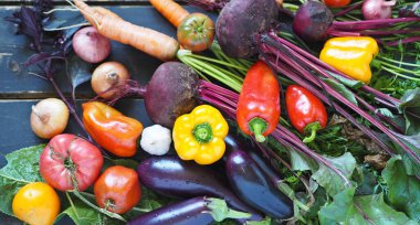 Üst görünüm kapalı. Tarımsal arkaplan. Kırsal ahşap arka planda bir yığın taze sebze..