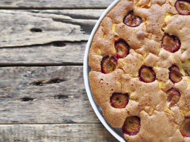 Üstten yakından bak. Tahta bir arka planda elma ve erikli Charlotte pastası.