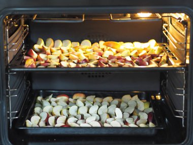 Kış için kurutulmuş meyve hazırlama mevsimi. Mutfak fırınında elmaları pişirme süreci..