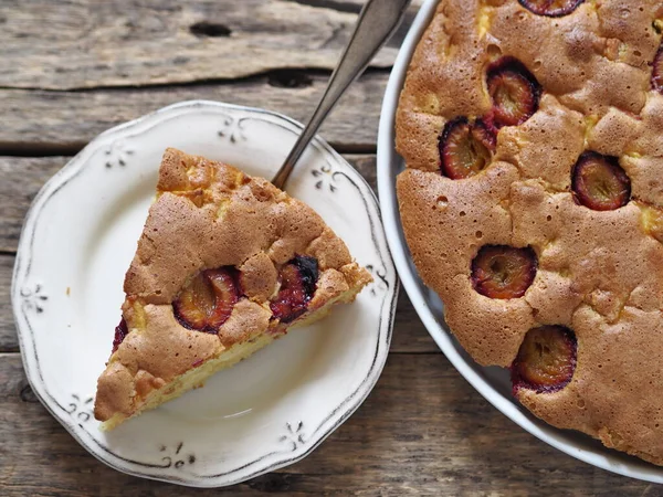 Üstten yakından bak. Tahta bir arka planda elma ve erikli Charlotte pastası.