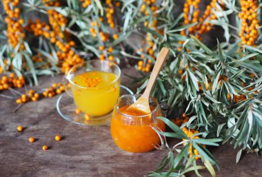 Ahşap bir arka planda taze deniz dikenli üzümlü deniz dikenli reçelli çay. Uzayı kopyala Renkli resim.